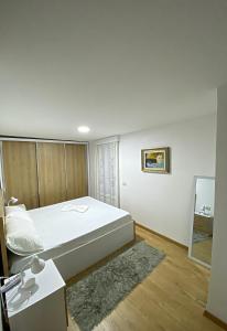 地拉那Guest House Laci的卧室配有一张白色大床和镜子