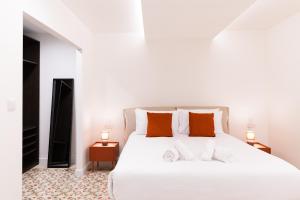 弗洛里亚纳Florette Suite Designer Finish in Floriana的卧室配有带橙色枕头的大型白色床