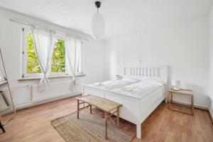 苏黎世Homey Comfort in Oerlikon的白色卧室设有白色的床和2个窗户