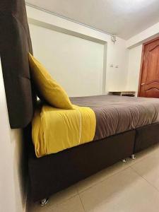 库斯科Apartamento en Cusco, Perú.的一间卧室配有一张黄色毯子床