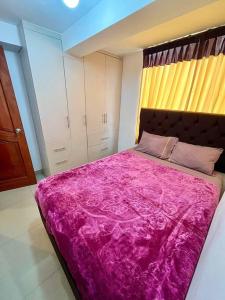 库斯科Apartamento en Cusco, Perú.的卧室配有一张大粉色毯子