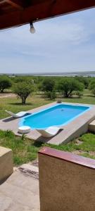ToayCuesta pampa casa de campo的享有大型蓝色游泳池的顶部景致