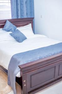 NarokCaptain Villa Narok的一张带蓝色枕头的木框床