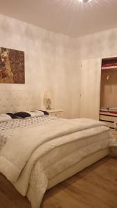 Prati di TivoLa Tana del Capriolo的白色的卧室设有一张大床和一个窗户