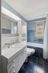 苏黎世Cozy 2 Bedroom Apartment in Zurich的浴室设有白色水槽和蓝色瓷砖