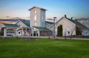 Kirkland LakeProspectors Inn的一座带绿色草坪的大型白色房屋