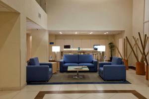 萨卡特卡斯萨卡特卡斯城市快捷酒店的大堂设有2把蓝色椅子和桌子