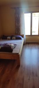 肯佩尼Cabana adi si mia cu pastravarie的一间卧室设有一张床和一个大窗户
