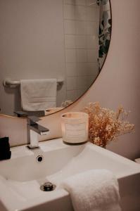 梅戈格Suite 205 - Destination Mont-Orford的浴室水槽设有蜡烛和镜子