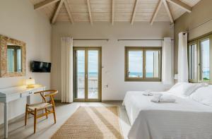 马拉松波利斯Callisto Seaside Homes & Suites的一间卧室设有两张床、一张桌子和窗户。