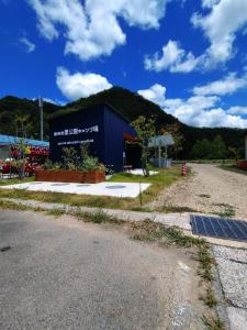 ShōbaraAyu no Sato Park Campsite - Vacation STAY 42166v的蓝色的建筑,旁边标有标志