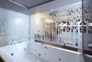 韦斯卡Hotel Sancho Abarca Petit SPA的带窗户的浴室内的白色浴缸