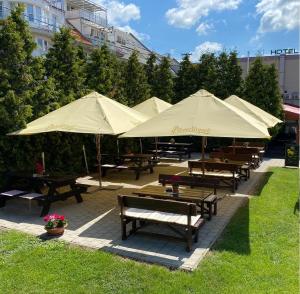 布拉迪斯拉发21号酒店的公园里一组带遮阳伞的野餐桌
