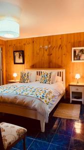 CuracavíKURALEMU Casa de Campo的一间卧室配有一张带木墙的大床