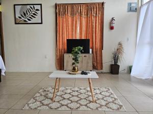 圣伊格纳西奥Cozy Flat in San Ignacio Close to Downtown!的客厅配有咖啡桌和电视