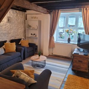 LlwyngwrilCosy modern cottage by the sea, heart of snowdonia的客厅配有两张沙发和一张桌子