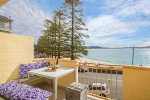 特里格尔Oceans at Terrigal a Beachfront Oasis的阳台配有桌椅,享有水景。