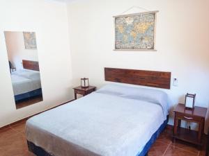 伊瓜苏港Departamentos Centricos Iguazu A.N的一间卧室配有床、两张桌子和镜子