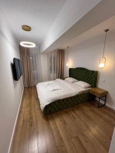 比斯特里察EightApartament的一间卧室配有一张大床和一张绿色沙发