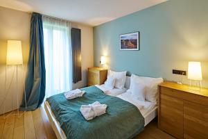 克拉斯纳利帕丽帕公寓酒店的一间卧室配有一张大床和毛巾