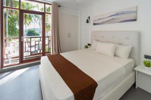 呼拉Silver Oasis Maldives的一间卧室设有一张床和一个大窗户
