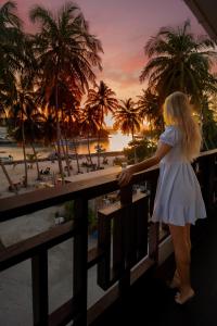 呼拉Silver Oasis Maldives的站在海滩上的阳台的女人
