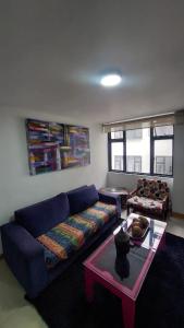波哥大APARTAMENTO CHAPINERO CENTRAL的客厅配有蓝色的沙发和桌子