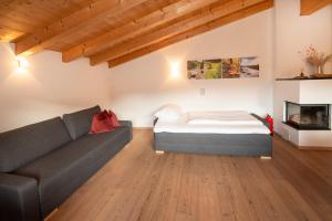 阿尔卑巴赫Natural Deluxe Apartments Alpbach的客厅配有床和沙发