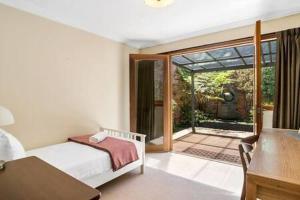 霍巴特Charming inner city home excellent base in Hobart的一间卧室设有一张床,并有通往庭院的门