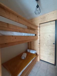 圣米舍德谢洛appartement montagne- le petit Chaillol的木制客房内的1间带1张双层床的卧室