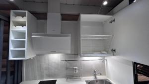 HimosLaakson Helmi 2 ,separate sauna, fireplace, lake的厨房配有白色橱柜和水槽