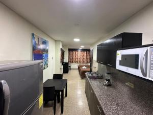 瓜亚基尔Residencia Terreros的一间带微波炉的厨房和客厅的客房