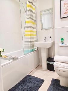 考文垂Impeccable 2-Bed House in Coventry的一间带水槽、浴缸和卫生间的浴室