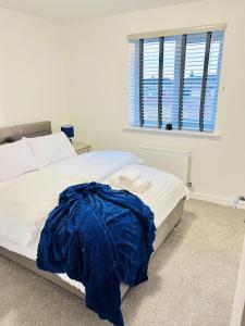 考文垂Impeccable 2-Bed House in Coventry的一间卧室配有一张带蓝色毯子的床