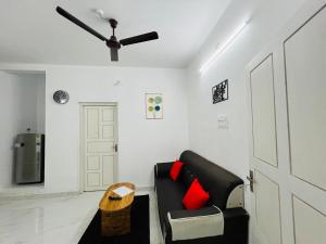 ThanniyamFurnished 2 BHK Family Apartments near Triprayar Shree Rama Temple - Beevees Homes Thriprayar的客厅配有黑色沙发和吊扇