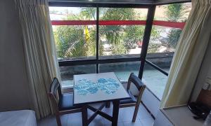 若昂佩索阿Apart-Hotel em Tambaú - Super Central com Vista Mar - Ap.113的窗户客房内的桌椅