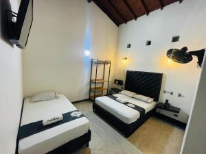 麦德林Hotel Panorama Medellín的一间设有两张床和一台电视的房间