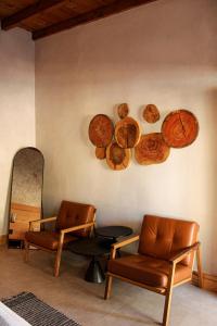 瓜达鲁佩镇MYA Hotel Boutique的一间设有两把椅子和木板的墙壁客房