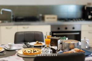 圣萨尔沃LIBERA HOUSE - Sweet Apartments的一张桌子上放着食物和橙汁