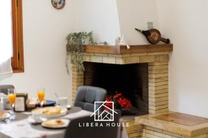 圣萨尔沃LIBERA HOUSE - Sweet Apartments的一间带壁炉的用餐室和一张餐桌