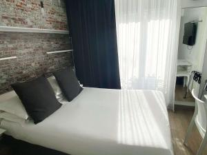 巴黎贝斯特韦斯特巴纳斯峰酒店的卧室配有白色的砖墙床
