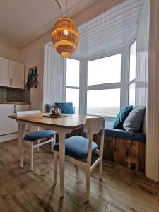 阿伯里斯特威斯Lovely Seafront 2 bed flat in Aberystwyth的厨房以及带桌椅的用餐室。