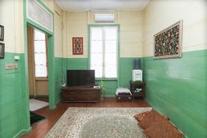 武吉丁宜Rumah Nizar (next to Ngarai Sianok)的客厅设有绿色的墙壁和平面电视。
