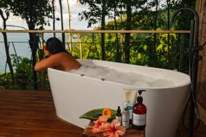 San PedrilloSCP Corcovado Wilderness Lodge的坐在甲板上浴缸里的人