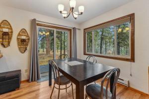 麦考尔New! Brundage Meadows 1 - Bright, cozy - 2story - wood stove - forest views - by trails, lake, town的一间带桌椅和窗户的用餐室