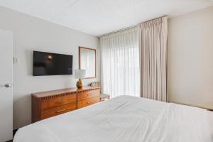 柏斯海滩Cape Suites Room 2 - Free Parking! Hotel Room的一间卧室配有一张床、梳妆台和电视。