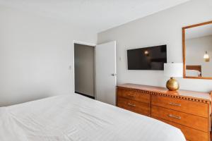 柏斯海滩Cape Suites Room 2 - Free Parking! Hotel Room的一间卧室配有一张床和一个带镜子的梳妆台