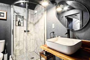 俄克拉何马城Spring Sanctuary Stylish Haven Near Asian Dist的浴室配有盥洗盆和带镜子的淋浴