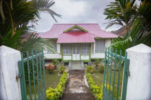 武吉丁宜Rumah Nizar (next to Ngarai Sianok)的粉红色屋顶和门的房子