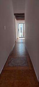 卡塔马卡SUITE A&F Habitación con baño privado的一条空的走廊,铺着瓷砖地板,设有一扇门